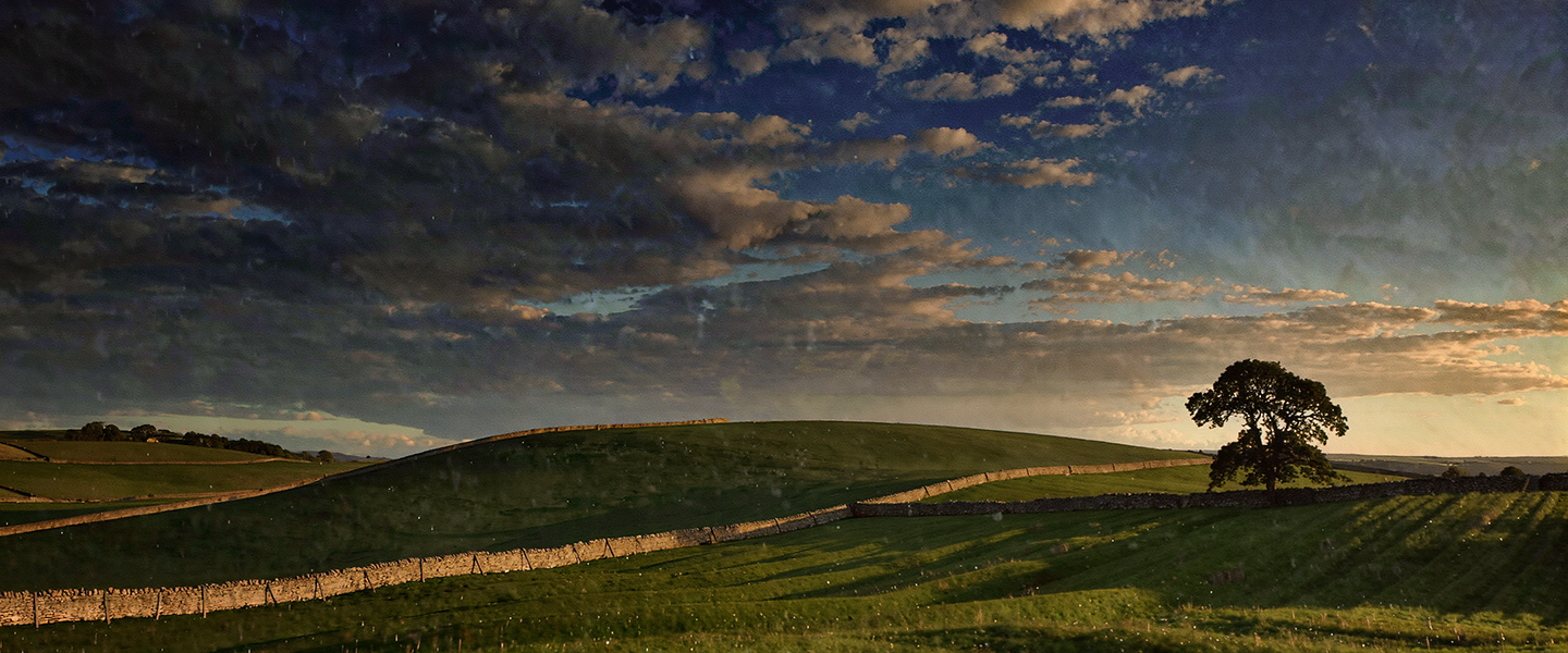Englische Landschaft bei Sonnenuntergang — sanfte Hügel, dramatischer Himmel